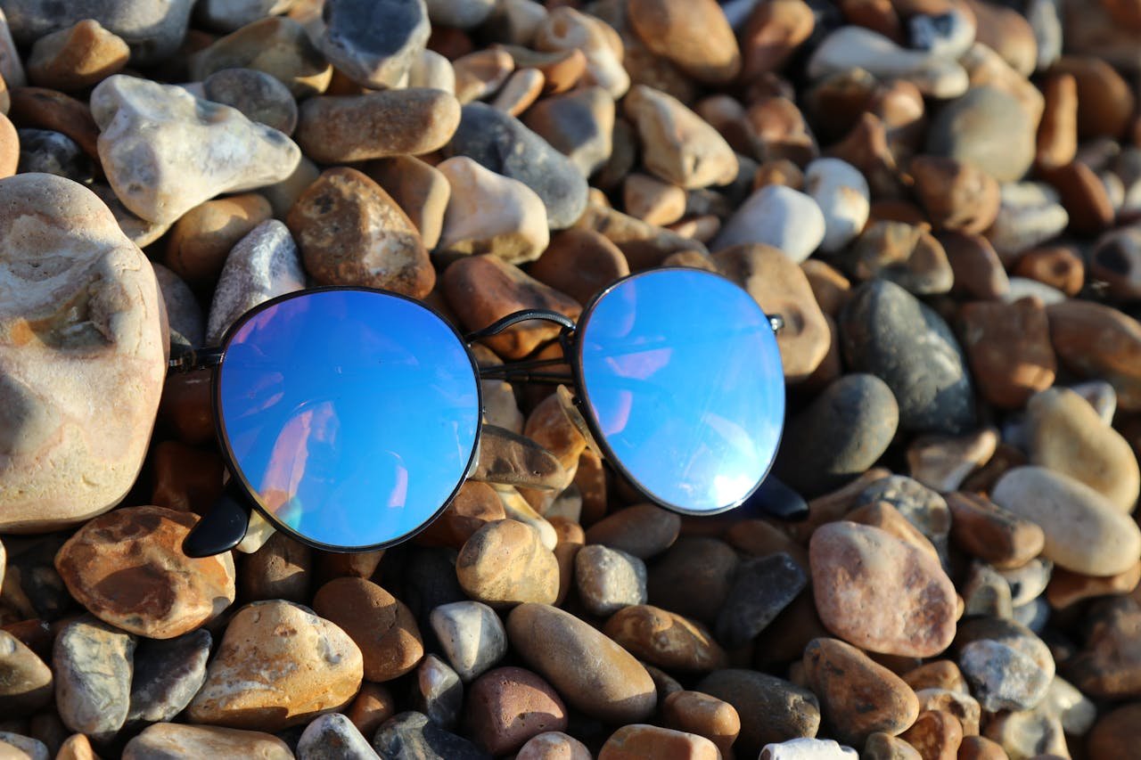 our-services-3 Stylish sunglasses with blue lenses on a pebbled beach in Brighton.